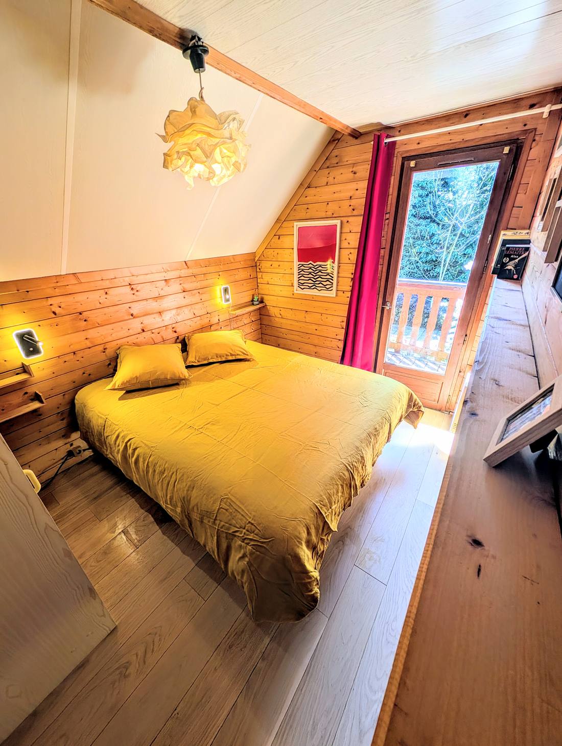 Chambre 1 du chalet, lit queen et porte-fenêtre ouvrant sur le balcon privé