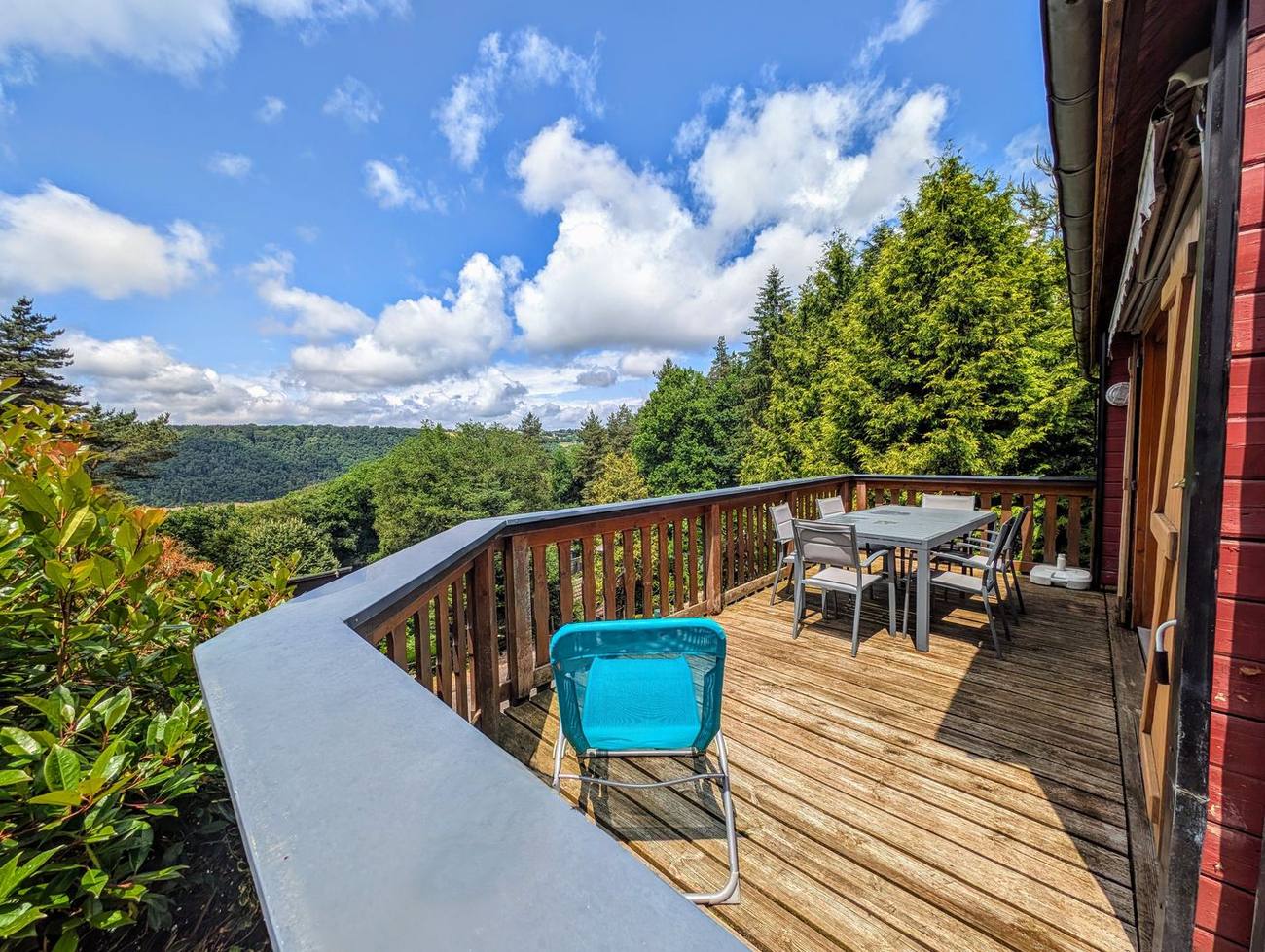 La terrasse du chalet ouverte sur les collines boisées